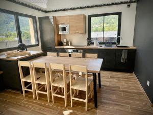 een keuken met een houten tafel en een aantal stoelen bij L’Éterle, maison de montagne in Aucun