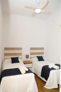 sypialnia z 2 łóżkami i wentylatorem sufitowym w obiekcie Casa La Herradura 2 w mieście Vejer de la Frontera
