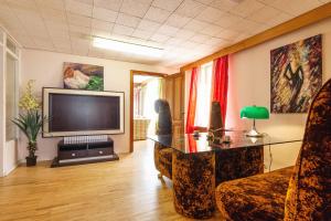 a living room with a television and a couch and a table at Old villa Kaprice Baltic Beach in Jūrmala