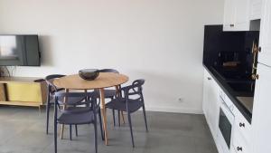 Il comprend une cuisine avec une table et des chaises ainsi qu'une télévision. dans l'établissement Nice: Bel Appartement Vue Mer avec Grande Terrasse, à Nice