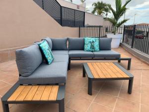 un divano e due tavoli su un patio di Villa View Candesol con Jacuzzi privado a Puerto de Santiago