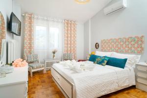 una camera da letto con un grande letto bianco con accenti blu di yiayia and papou Luxury House a Limenas
