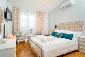 a bedroom with a large white bed with blue accents at yiayia and papou Luxury House in Limenas
