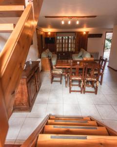 una sala da pranzo con tavoli e sedie in legno di Hotel y Cabañas Le Village a San Martín de los Andes