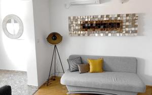 - un salon avec un canapé gris et des oreillers jaunes dans l'établissement Apartments Villa Bubi, à Pula