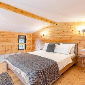 ウルツィニにあるOlive Treasureの木製の壁の部屋にあるベッドのある寝室