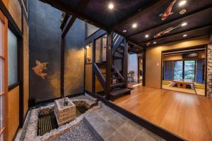 una sala de estar abierta con chimenea y suelo de madera. en 京恋 黄金屋 en Kyoto