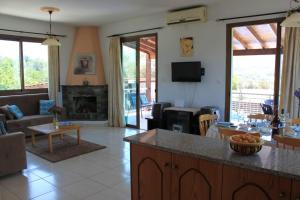 eine Küche und ein Wohnzimmer mit einem Sofa und einem Tisch in der Unterkunft Yiannos House in Evrykhou