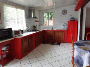 a kitchen with red cabinets and a red refrigerator at Les Lierrres in Cilaos