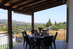 a table and chairs on a balcony with a view at Yiannos House in Evrykhou