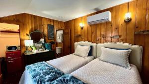 two beds in a room with wood paneled walls at Peaceful Cabin in Idyllwild