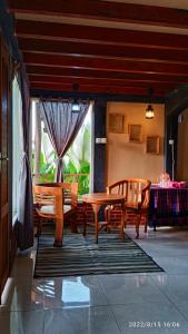 una sala da pranzo con tavolo, sedie e una finestra di Ecobromo a Pasuruan