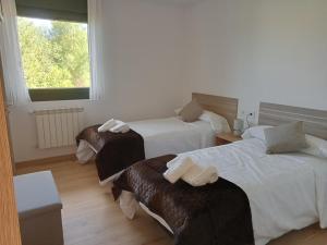 a hotel room with two beds and a window at Pension Xacobeo Lavacolla in Lavacolla