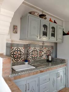 a kitchen with blue cabinets and a sink at Dar Azahara in Fès