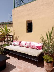 eine Couch auf einer Terrasse neben einem Gebäude in der Unterkunft Dar Azahara in Fès