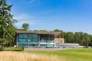a large building with glass windows and a grass field at The Kilnwick Percy Resort and Golf Club in Pocklington