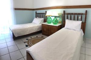 a bedroom with two beds and a lamp on a table at IRIS Chania in Chania Town