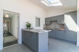 a kitchen with gray cabinets and a sink at Archers Lodge in Stevenage
