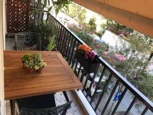 a wooden table and chairs on a balcony with flowers at IRIS Chania in Chania