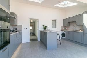 a large kitchen with gray cabinets and a sink at Archers Lodge in Stevenage