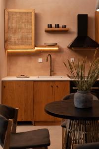 uma cozinha com um lavatório e uma mesa com cadeiras em Opuntia Suites em Naxos Chora
