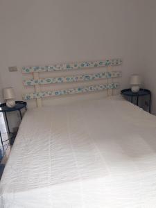 um quarto com uma cama com dois candeeiros em duas mesas em Casa Vittoria em Roccella Ionica