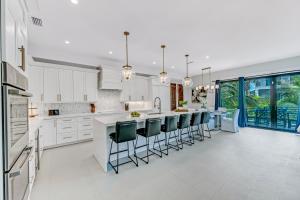 a kitchen with white cabinets and a large island with bar stools at Endless Summer in Sarasota