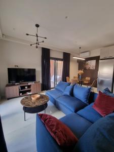 un soggiorno con divani blu e un tavolo di Fiorzakynthos City Apartments a Città di Zante