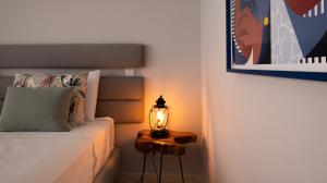 Schlafzimmer mit einem Bett und einer Lampe auf einem Tisch in der Unterkunft House J São Rafael - By Bedzy in Albufeira