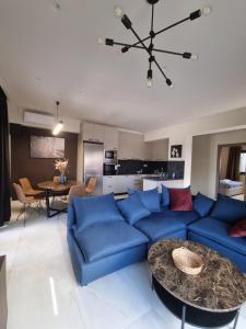 a living room with a blue couch and a table at Fiorzakynthos City Apartments in Zakynthos Town