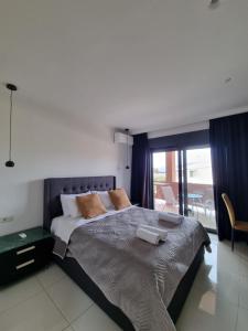 una camera con un grande letto e un balcone di Fiorzakynthos City Apartments a Città di Zante