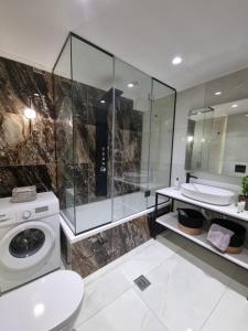 bagno con lavatrice e lavandino di Fiorzakynthos City Apartments a Città di Zante
