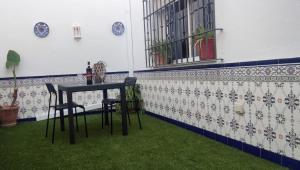 een tafel en stoelen in een kamer met groen gras bij Apartamento completo Alhaurín de la Torre in Alhaurín de la Torre
