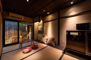 a room with a bed and a tv and a window at Kyokoi Kiyomizugojo in Kyoto