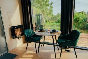 1 mesa y 2 sillas en una habitación con ventana en Juniper Villas - Standard & Delux, 
