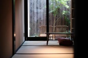 a room with a window with a bench on a balcony at Kyokoi Kiyomizugojo in Kyoto +6 photos
