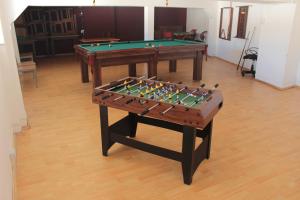 two tables with a pool table in a room at Alhambra Hotel in San Antonio