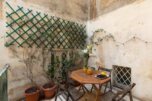 una mesa y sillas en una habitación con plantas en iFlat Monti Charming Apartment, en Roma