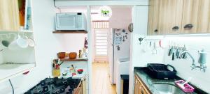 una pequeña cocina con fregadero y nevera. en COPDS0104 - Tranquilidade em condomínio particular, en Salvador