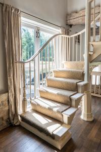 a white staircase in a home with a window at Stunning Victorian Converted Mill, 3 BDR Retreat in Cheltenham