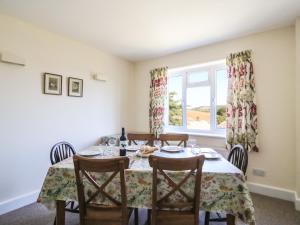 a dining room with a table and chairs and a window at Thorncroft in West Bay