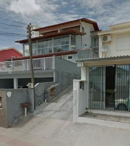 um edifício de apartamentos com uma varanda e um portão em Aptos 5 pessoas a 50m do mar 025 em Florianópolis
