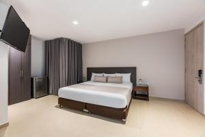 a bedroom with a bed and a flat screen tv at Hotel Elite in Barrancabermeja