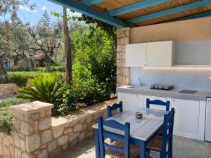 a kitchen with a table and chairs on a patio at Casa Marimar Boutique Bungalows & Suites in Porto Heli