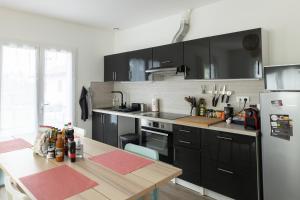 cocina con armarios negros y mesa de madera en Gure Chokoa en Bardos