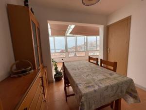 a dining room with a table and a large window at A Casiña De Abaixo in A Guarda