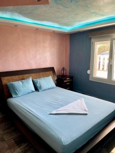 a bed in a bedroom with a blue wall at Νέα μεσσαγγαλα luxury suite by MAKHOME no 2 in Nea Mesangala