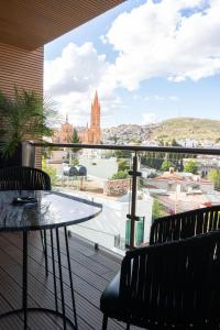 d'un balcon avec une table et des chaises offrant une vue sur la ville. dans l'établissement Casa Cuarzo Hotel Boutique, à Zacatecas