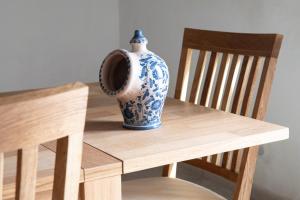 een blauwe en witte vaas op een houten tafel bij Casale Manca - Luxury Country House - The quiet with a sea view in Licata +22 foto's