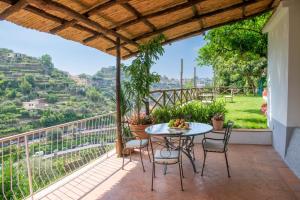 d'une terrasse avec une table et des chaises sur un balcon. dans l'établissement IL NIDO DEGLI ANGELI, à Ravello